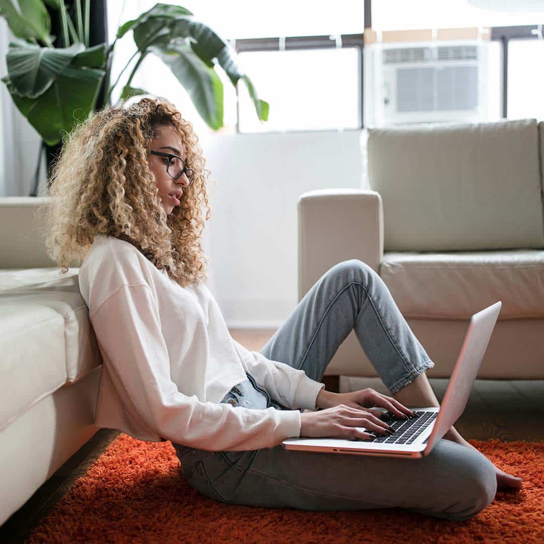 Frau sitzt am Notebook auf dem Boden - shopstartups Blog